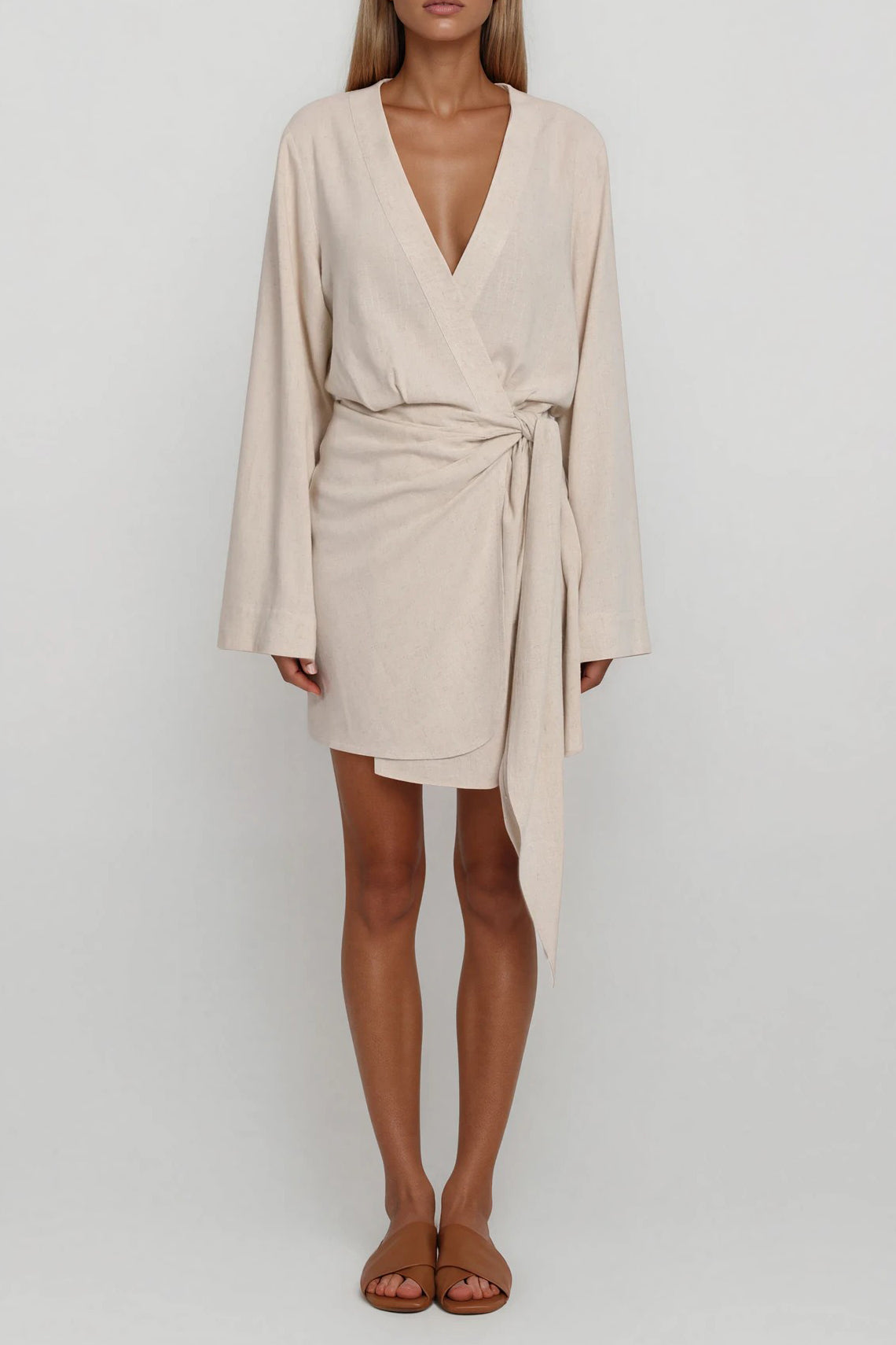 Beiges Wickelkleid mit langen Ärmeln und asymmetrischem Saum, frontale Gesamtansicht