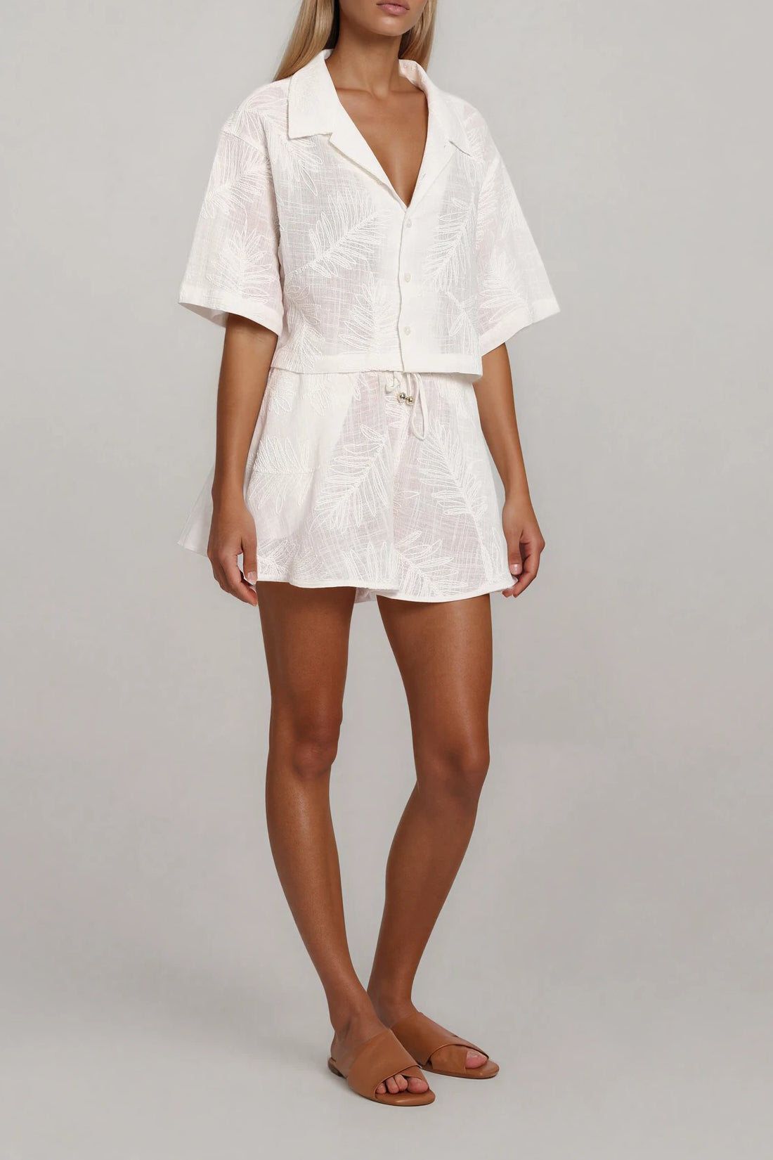 Off-White Set mit strukturierter Bluse und Shorts, leichte Transparenz, schräge Ansicht von vorne