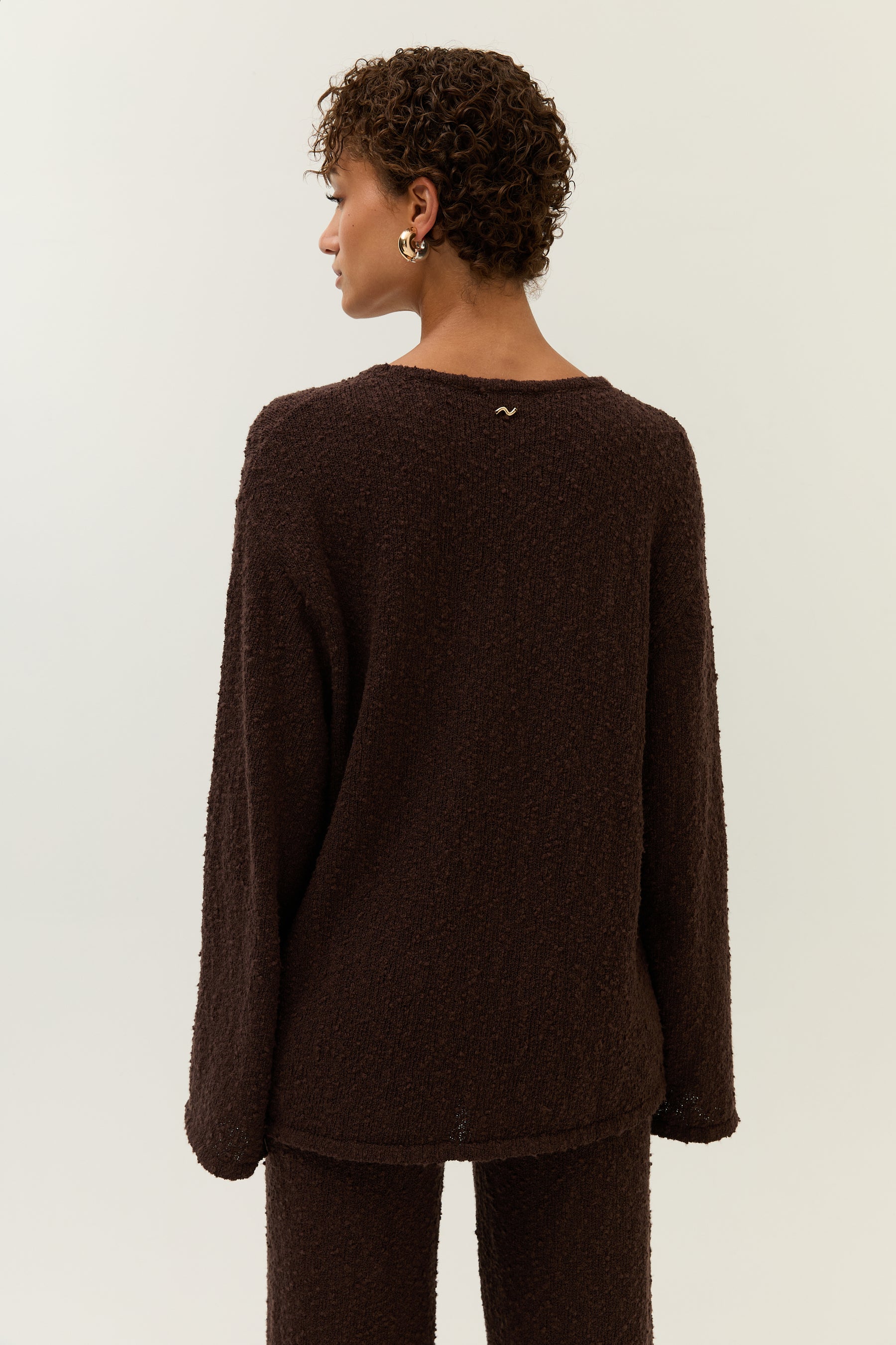 Rückansicht des Looks mit Fokus auf das minimalistische goldene Lezu-Logo unter dem Halsausschnitt.