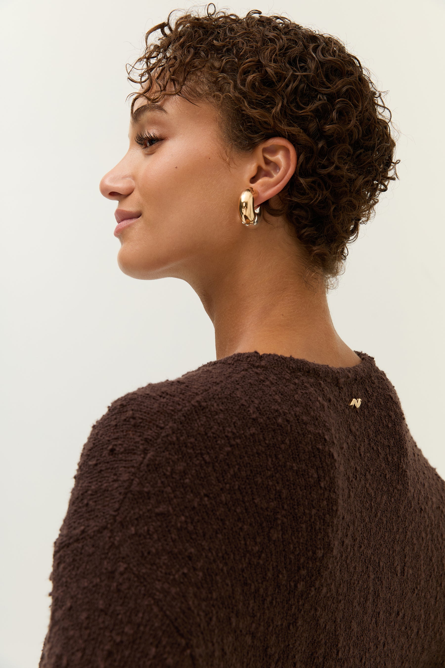 Seitliches Close-up auf das goldene Lezu-Logo und die texturierte Oberfläche des Stoffes.