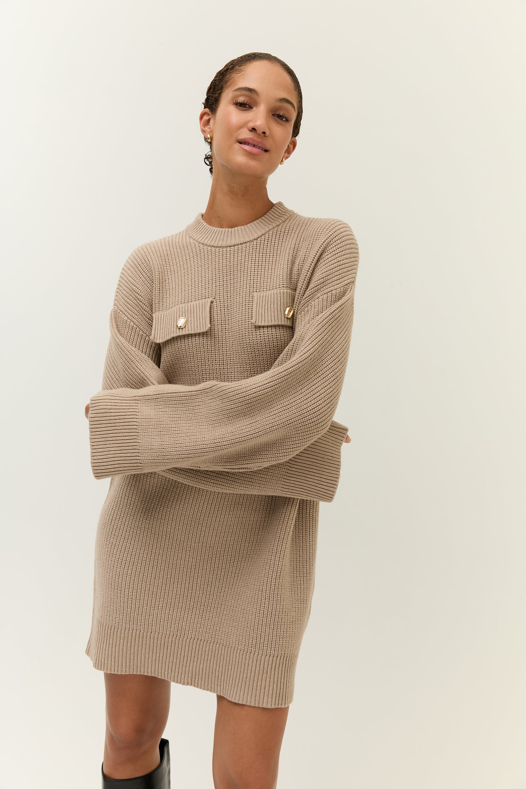 Halbportrait, Arme verschränkt
Locker geschnittenes Strickkleid mit strukturierter Oberfläche und zwei Klappentaschen auf Brusthöhe.