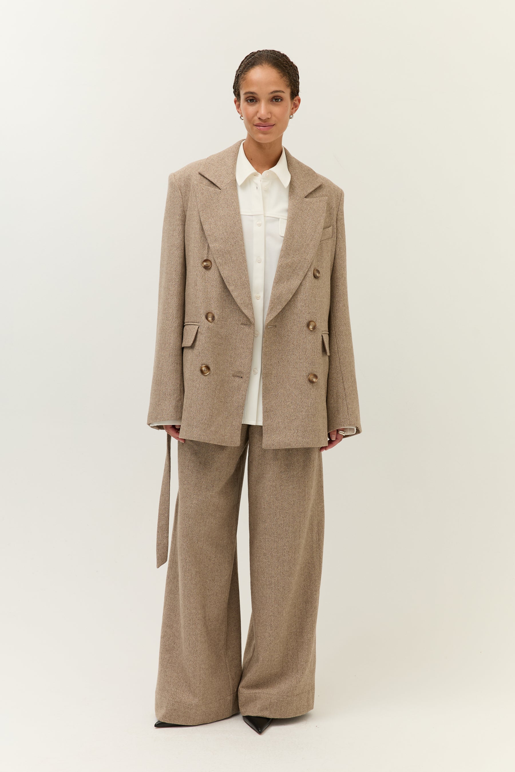 Offener Blazer-Look
Model trägt Blazer offen über einem weißen Hemd. Hose im gleichen Stoff, gerade geschnitten mit weitem Bein.