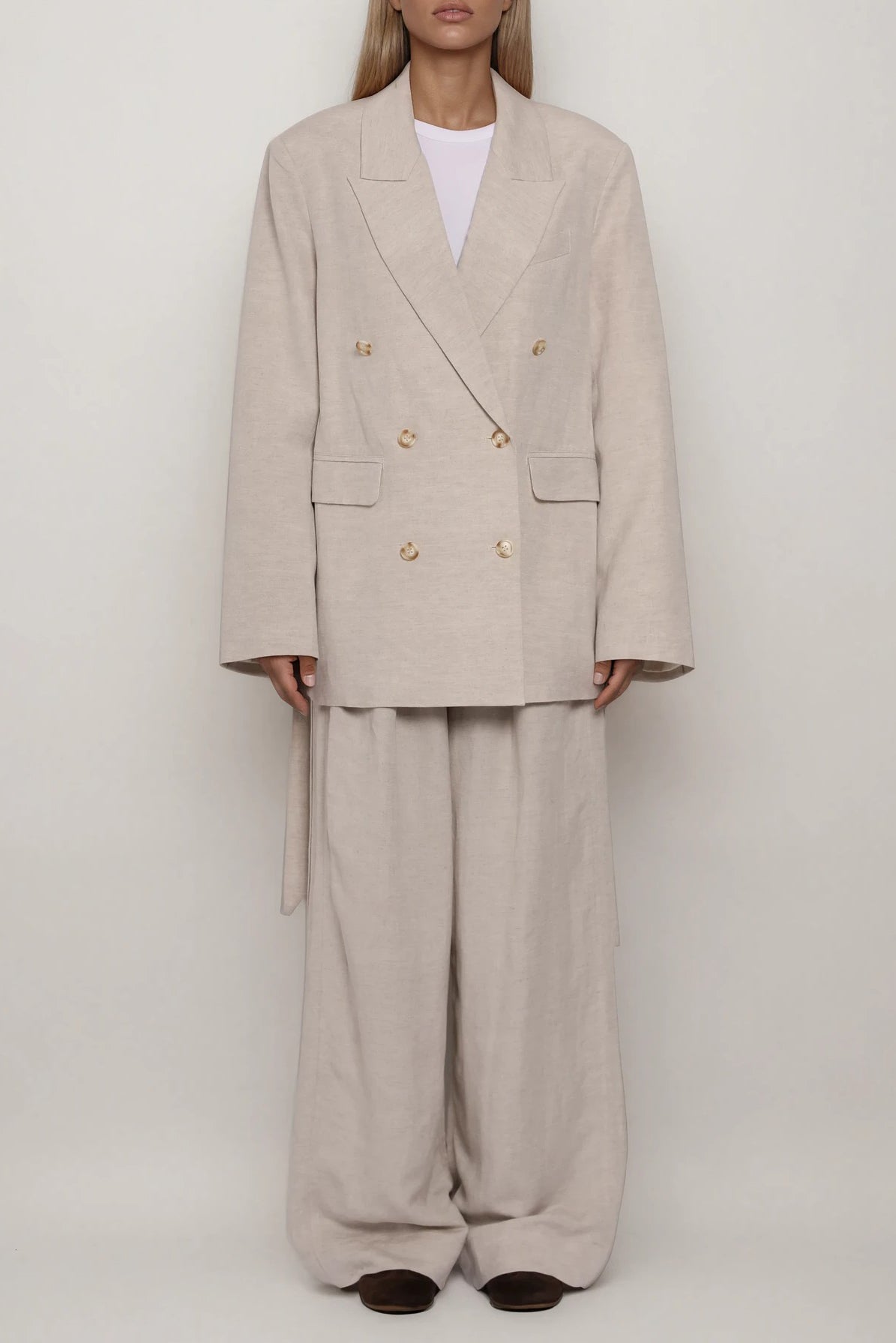 Beiger doppelreihiger Blazer mit Reverskragen und Knopfleiste, gerade Passform, kombiniert mit weiter Hose, Ganzkörperansicht