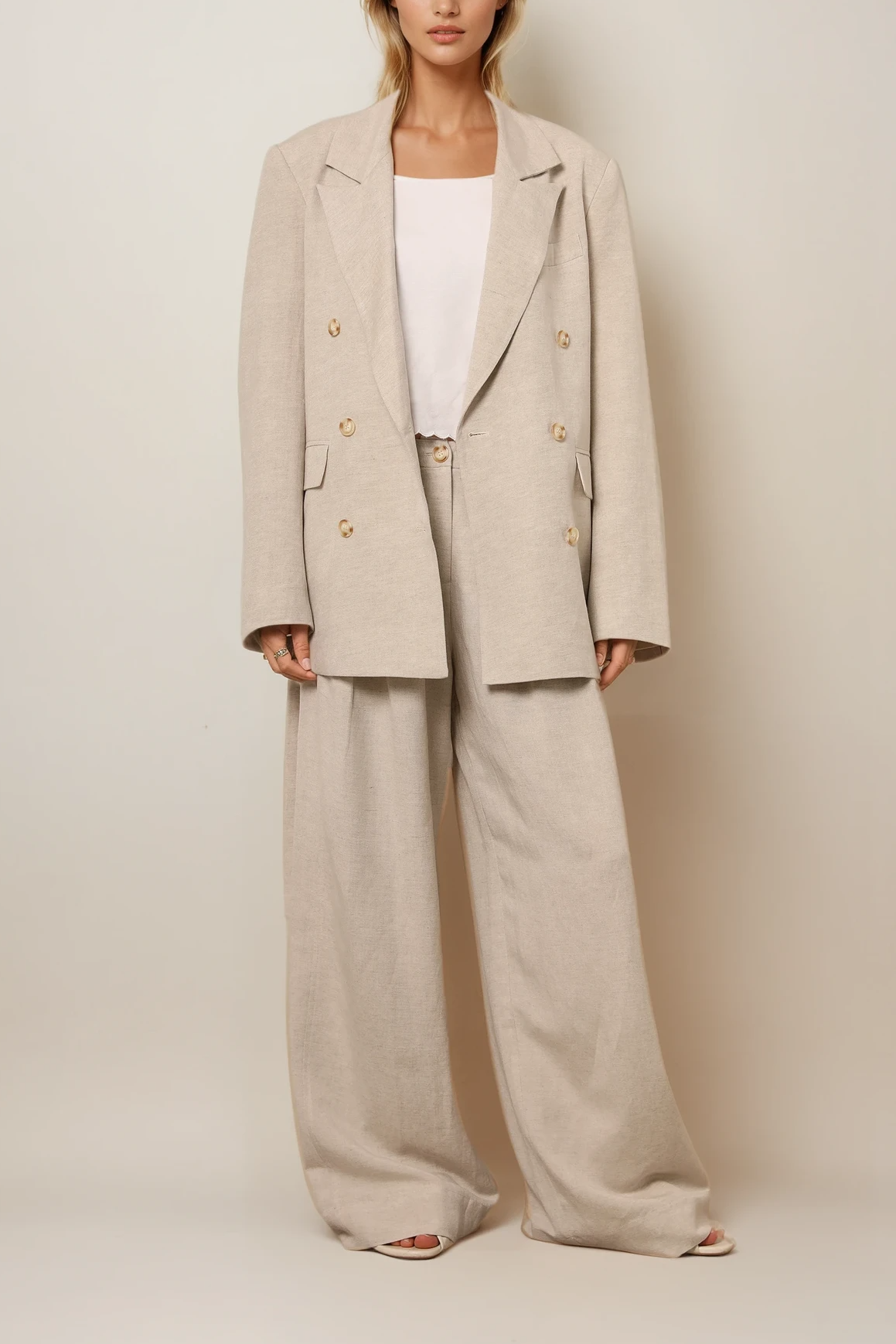 Lookbild: Locker geschnittener Blazer in Warmgrau mit passender weiter Hose und schlichtem Top, doppelte Knopfleiste und entspannte Silhouette.