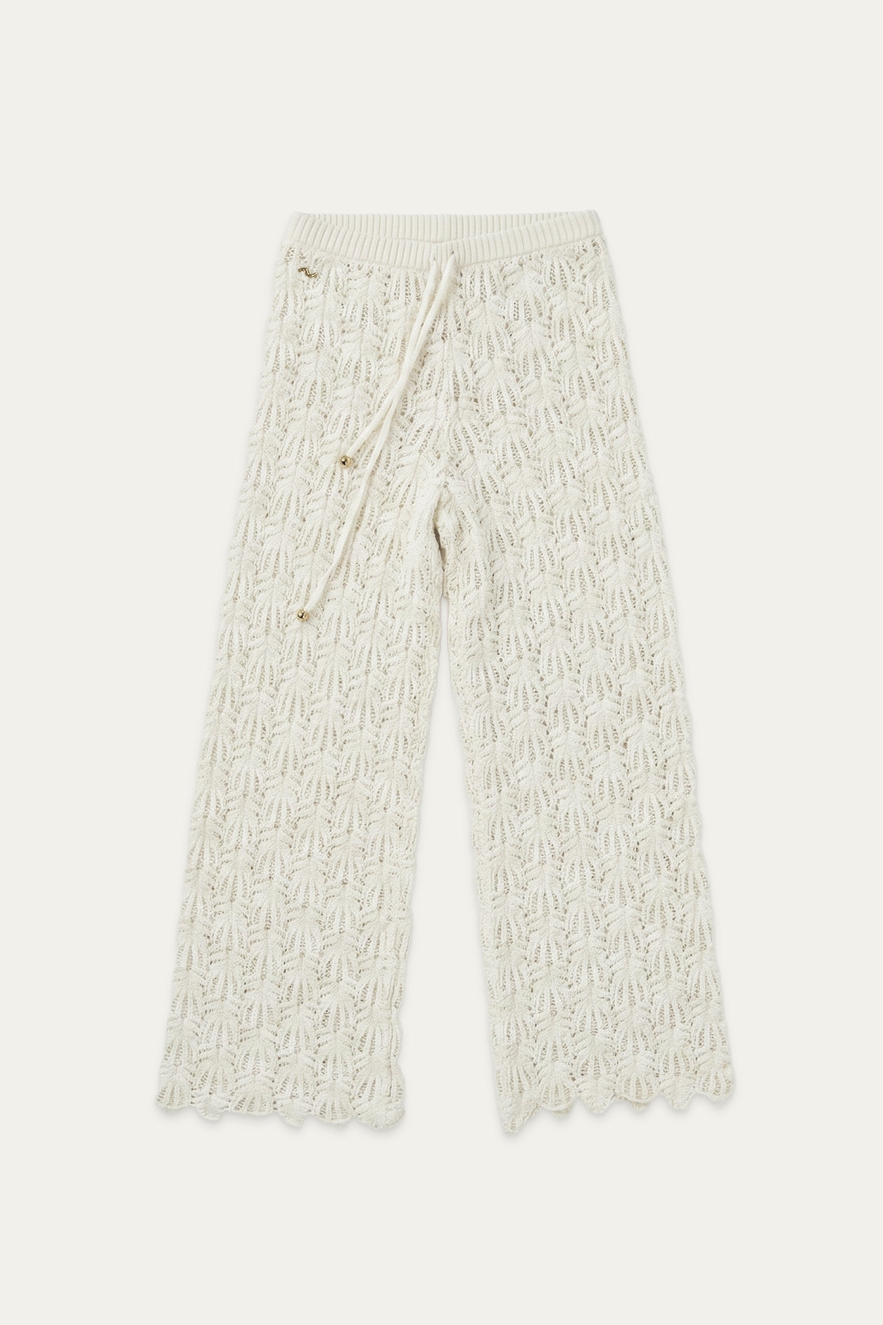 Frontansicht einer weißen Strickhose mit elastischem Bund und Bindeband, kombiniert mit Cardigan
