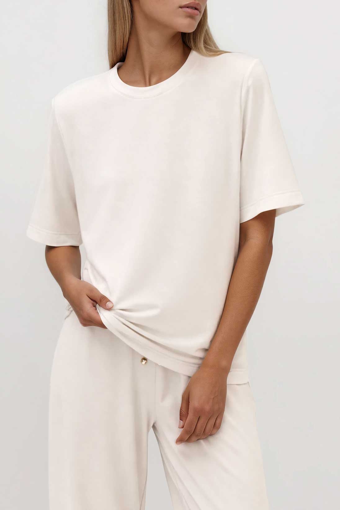 Cremefarbenes T-Shirt mit Rundhalsausschnitt und kurzen Ärmeln, locker geschnitten, kombiniert mit weiter Hose, Seitenansicht