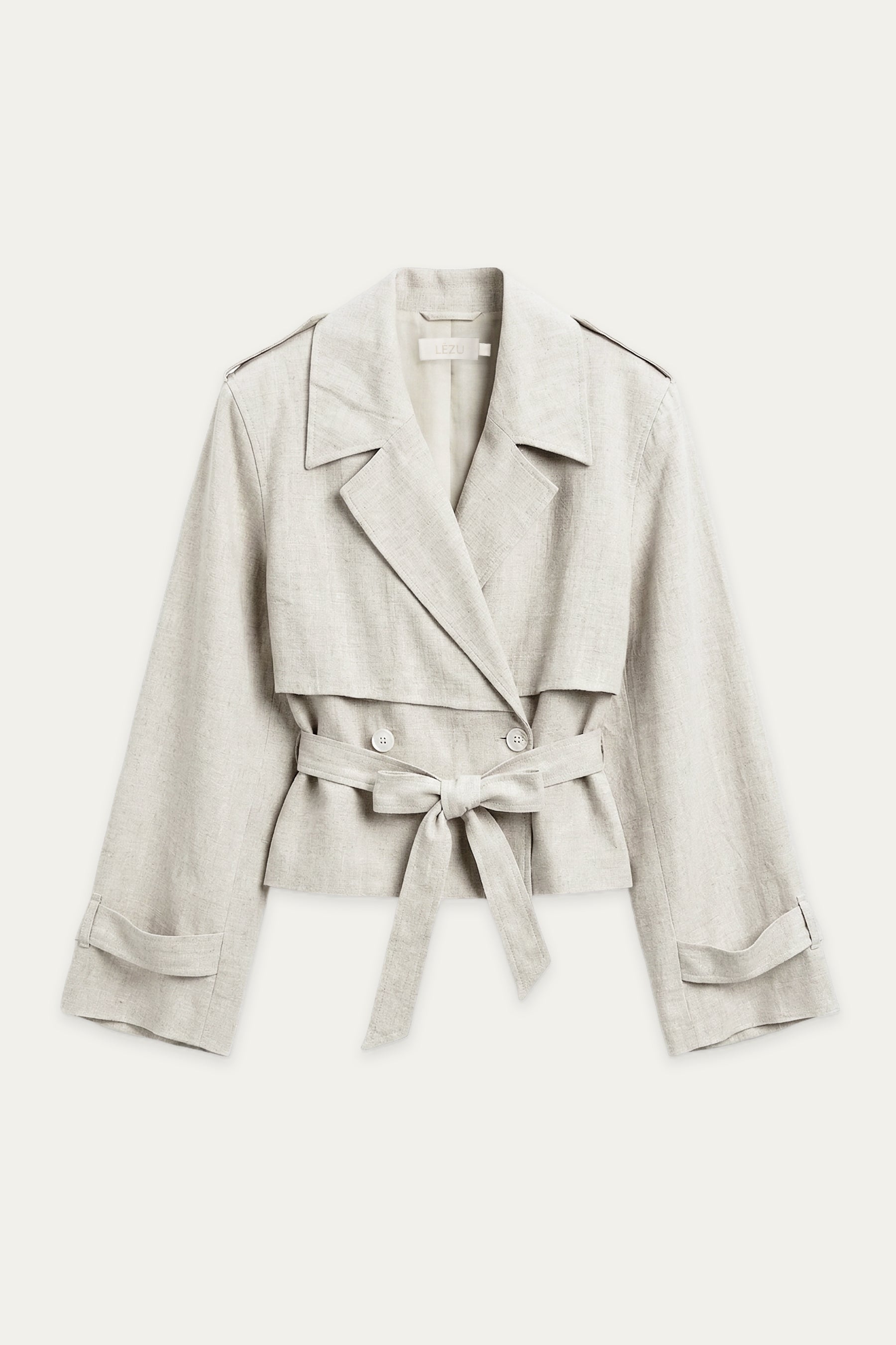 Kurze Trenchjacke in Off-White mit Reverskragen, doppelreihiger Knopfleiste und Bindegürtel auf Taillenhöhe.