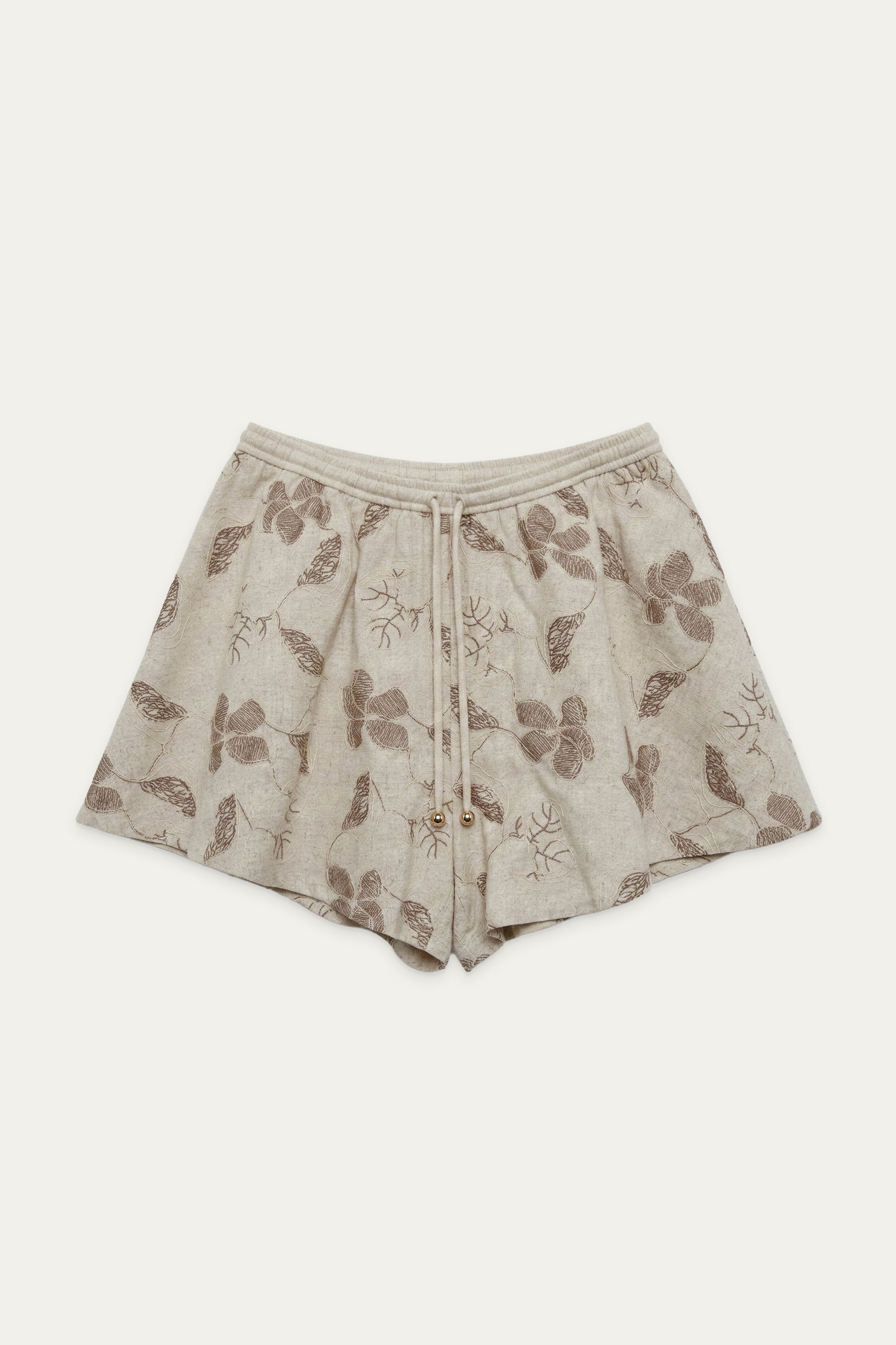 Beige Shorts mit floralem Muster, elastischem Bund und Bindeband, flach liegend vor neutralem Hintergrund