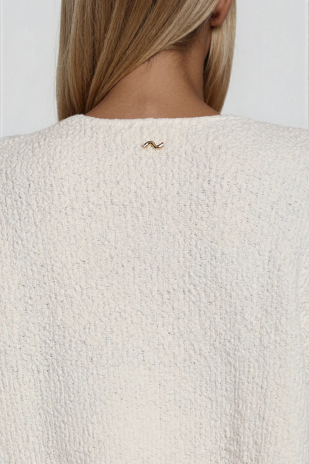 Detailaufnahme der strukturierten Strickoberfläche in Offwhite mit feiner Textur