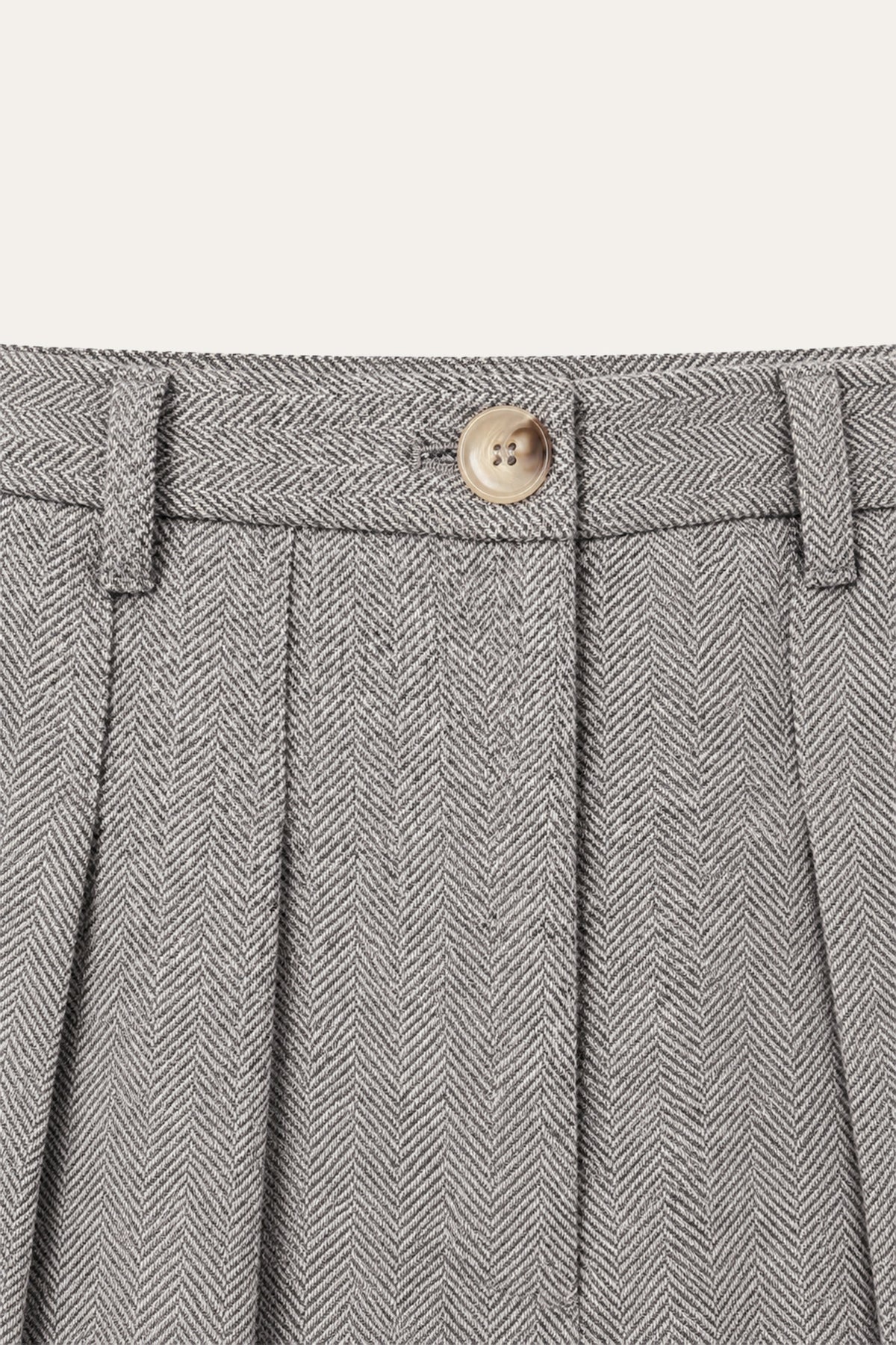 Detailaufnahme der grauen Ada Pants mit Fischgratmuster von vorne: Bund mit Gürtelschlaufen, hellem Knopf und Bundfalten