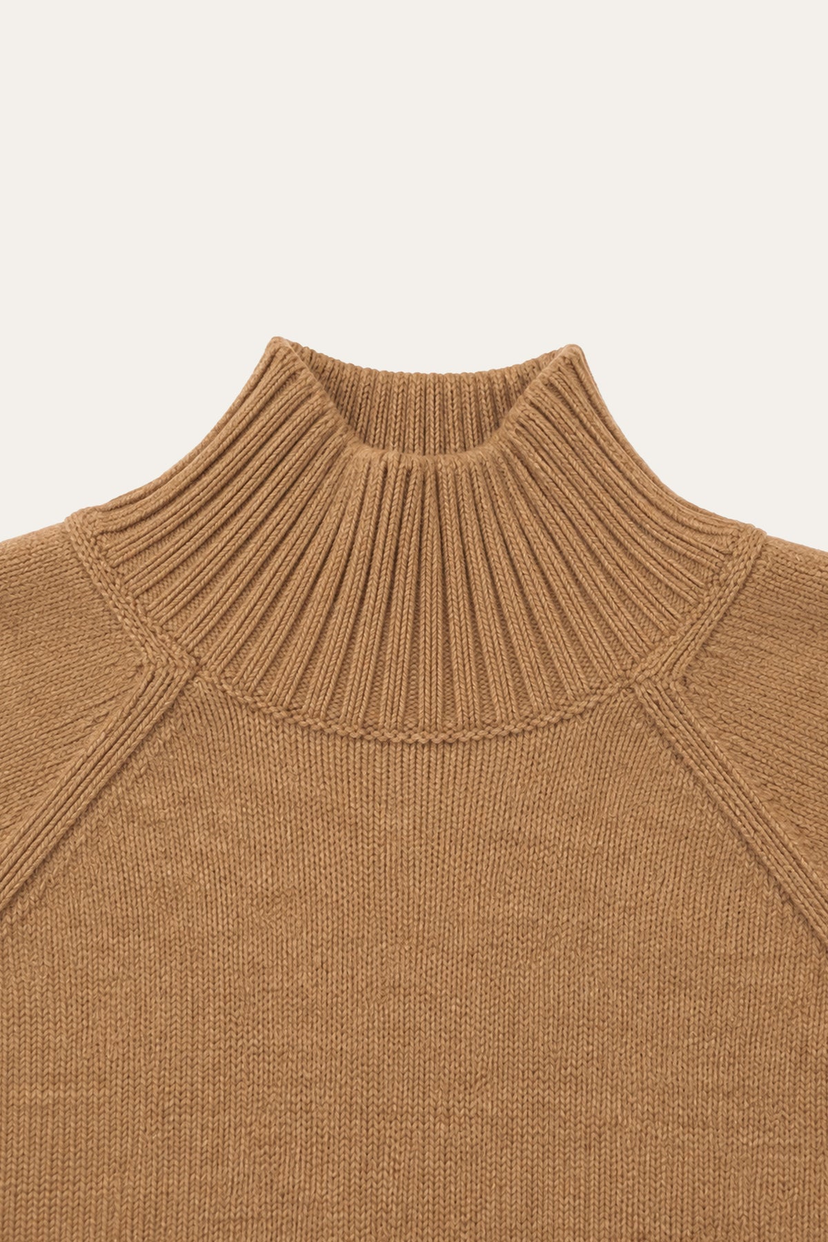 Detailansicht der Rückseite eines camelbraunen Strickpullovers mit hohem, geripptem Stehkragen und sichtbaren Raglannähten.