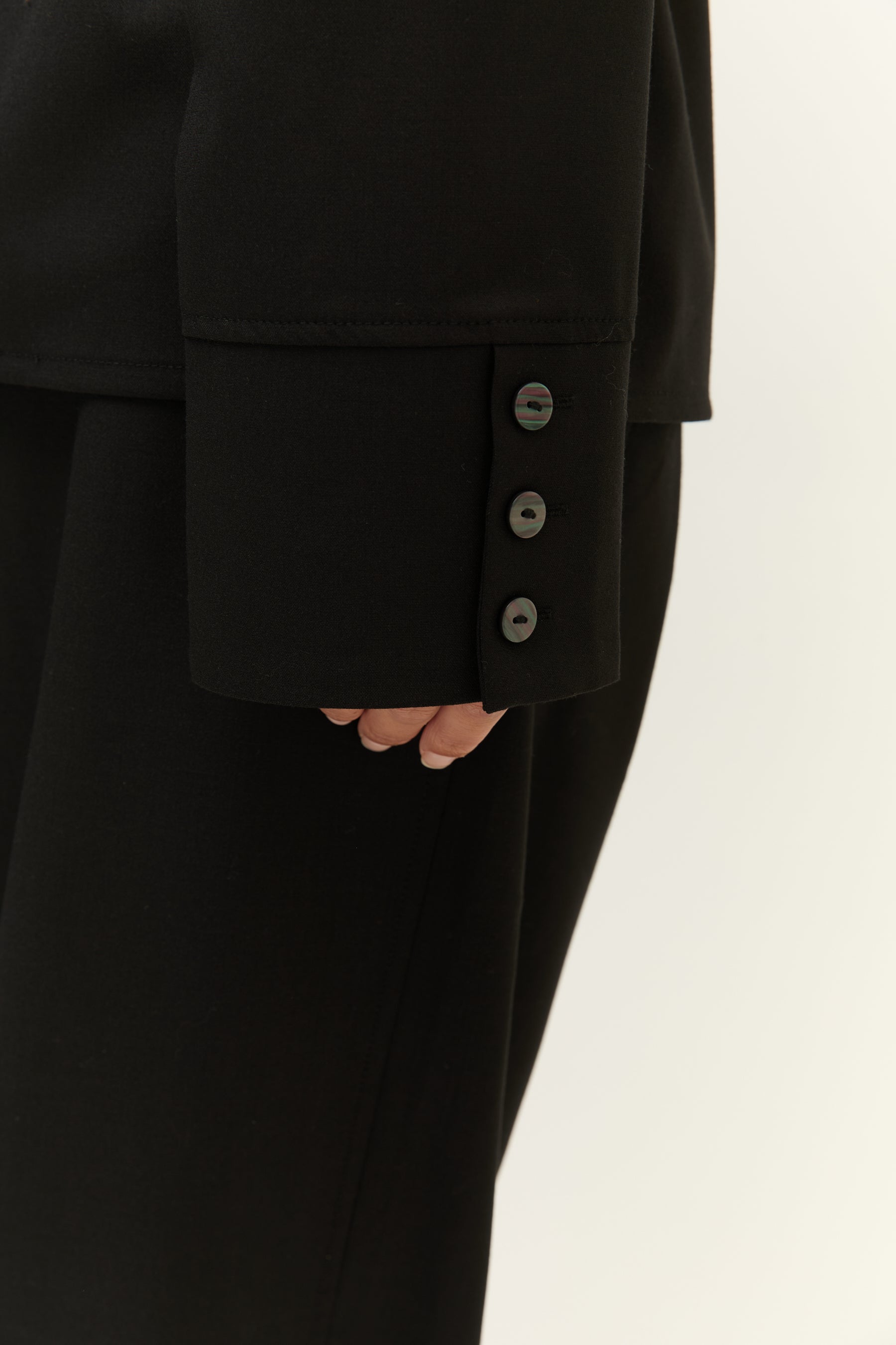Detailansicht der Manschette mit drei schwarzen Knöpfen.