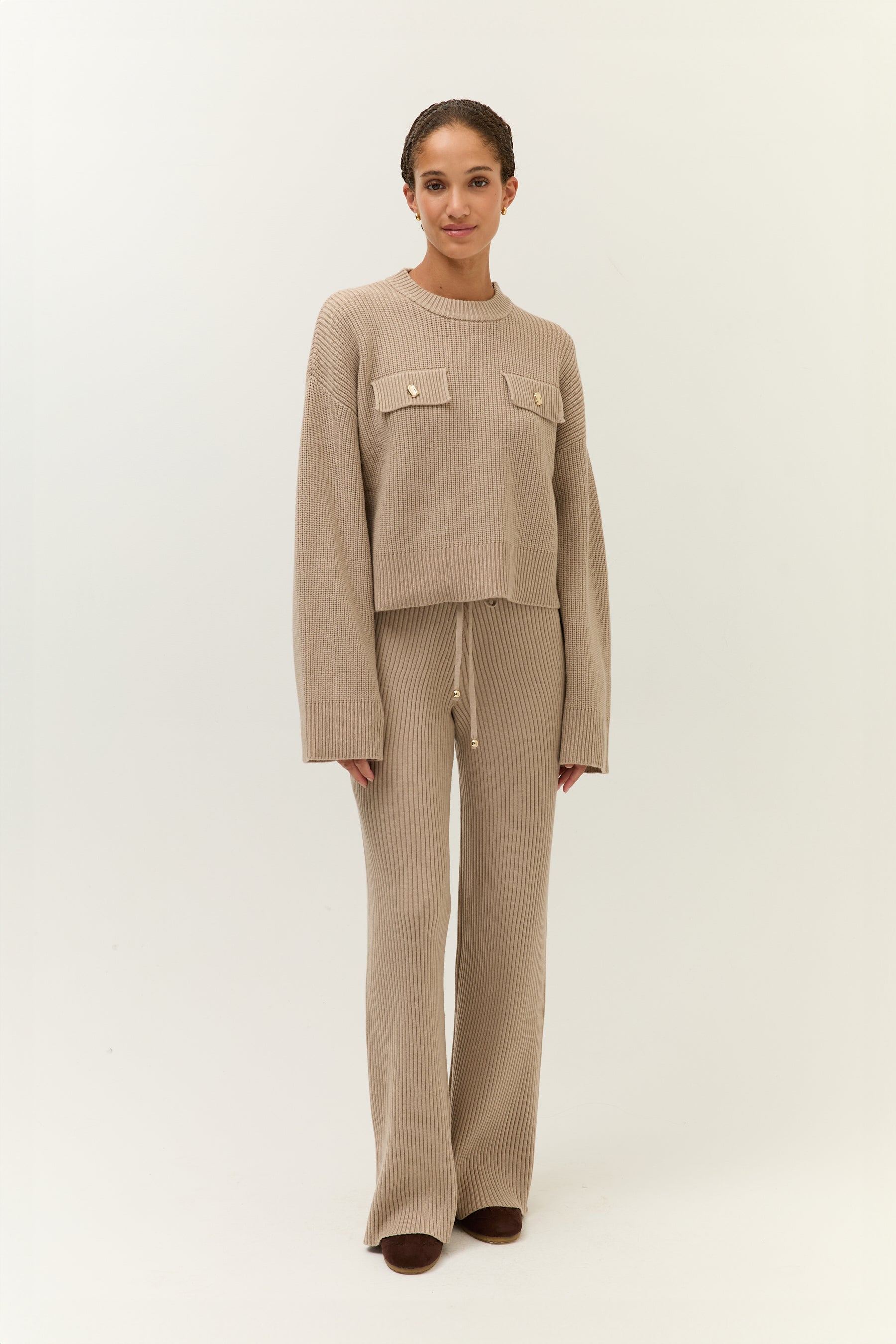 Frontalansicht des Outfits mit leicht versetztem Blick – Fokus auf das symmetrische Design und die goldenen Details.