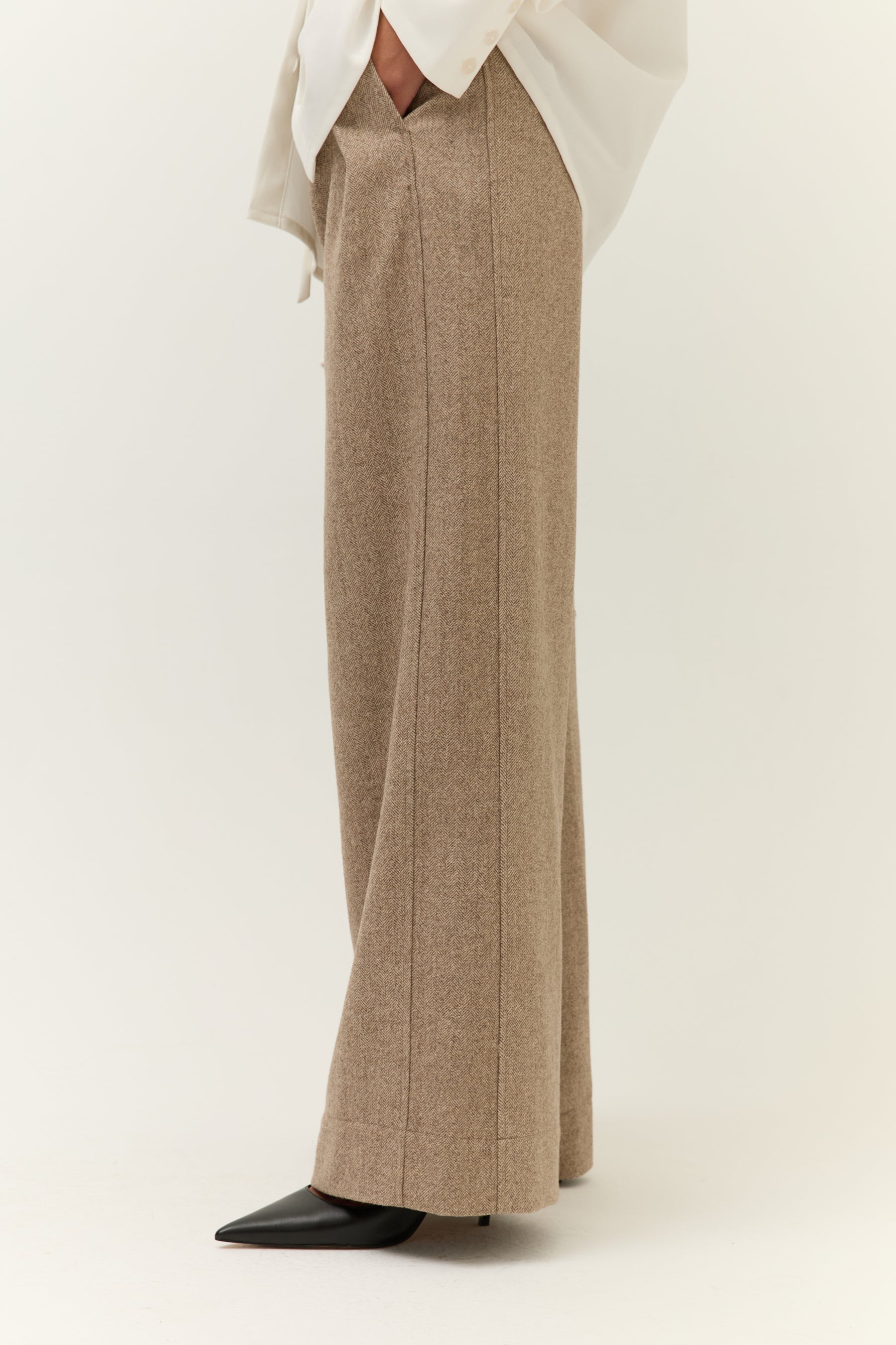 Seitenansicht Hose & Schuhe
Seitenansicht der hellbraunen Wide-Leg-Hose mit Bügelfalte, kombiniert mit spitz zulaufenden schwarzen Schuhen.