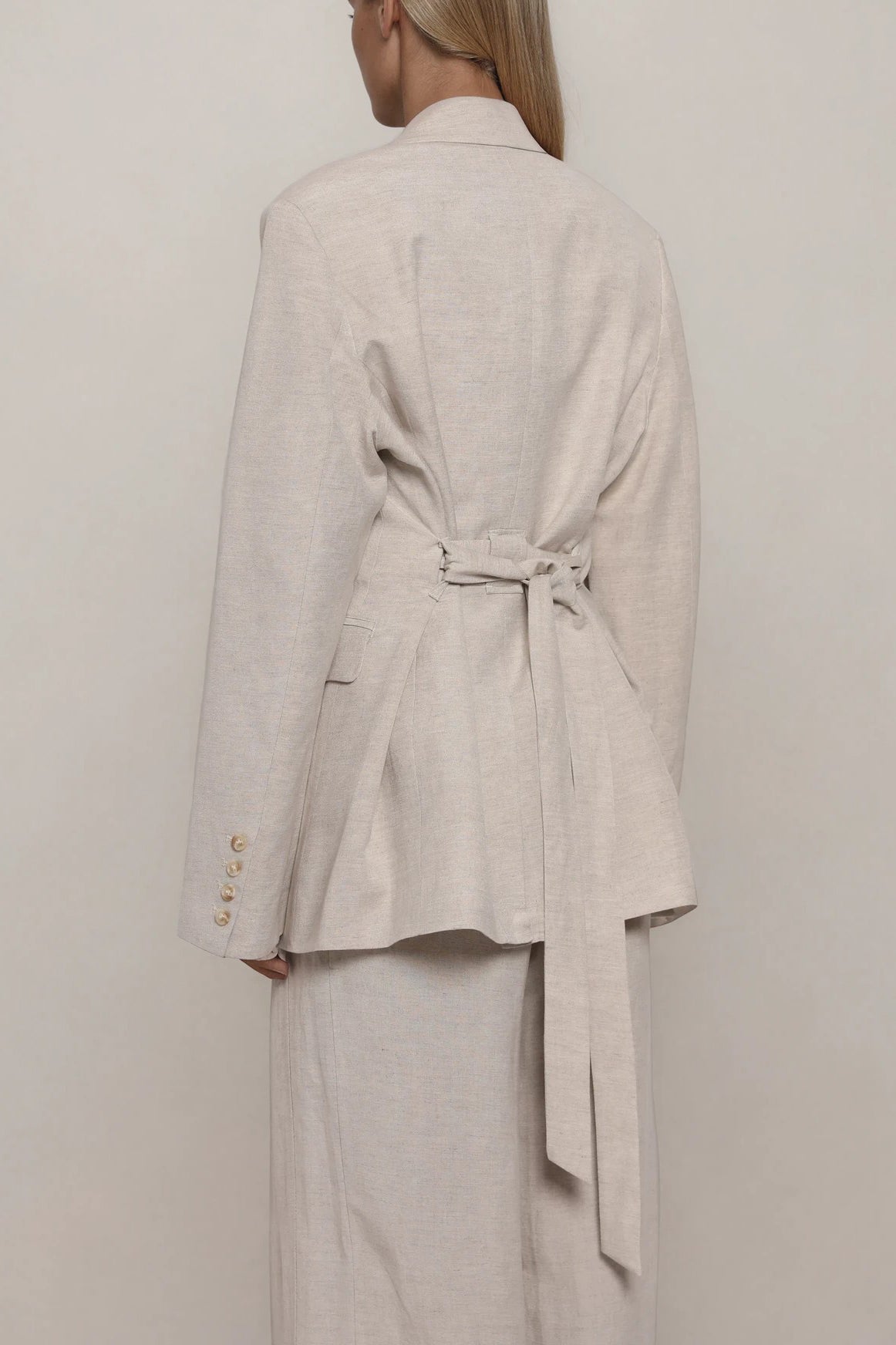 Beiger Blazer mit Taillengürtel und Schößchen, lange Ärmel mit Knopfdetails, Rückansicht